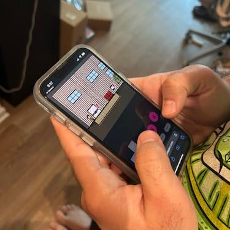 Holding a phone running the personalized pixel game